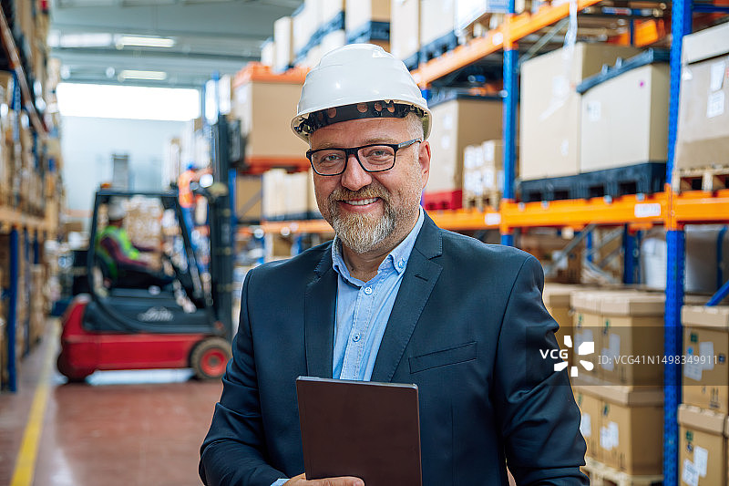 笑容满面的商人在仓库走廊里图片素材