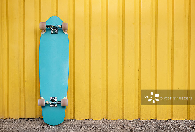 靠在黄色墙壁上的长板图片素材