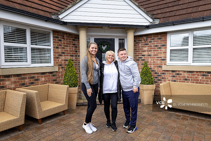 母亲、女儿和儿子站在家前图片素材