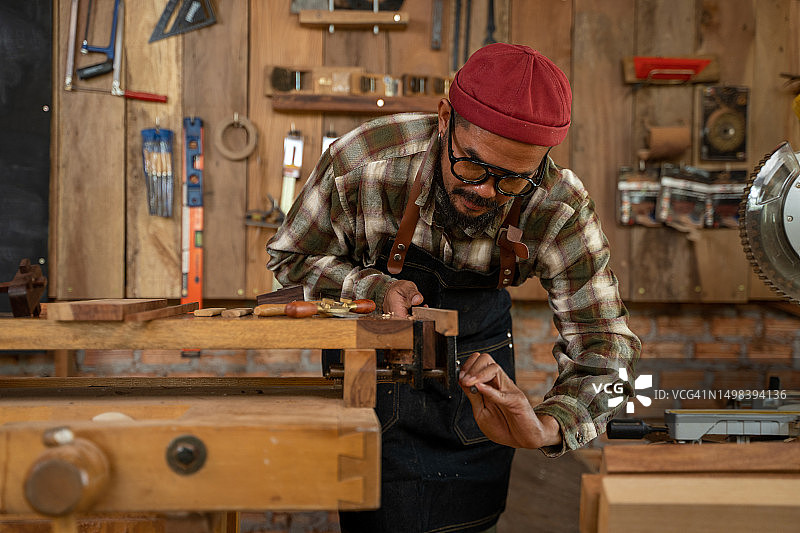 在木工车间使用设备在木桌上工作的专业木匠图片素材