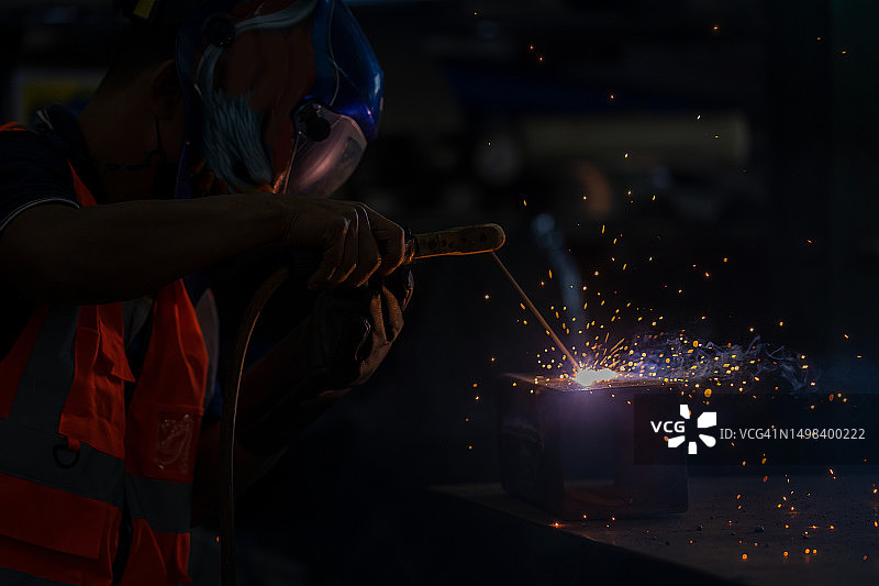 工厂中焊接工业汽车零件的工人图片素材