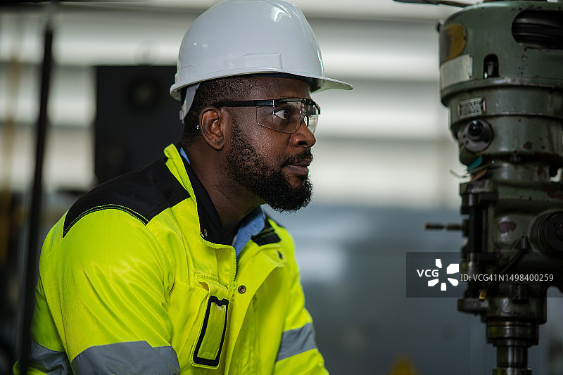 戴着安全帽在重工业制造厂工作的机械工程师图片素材