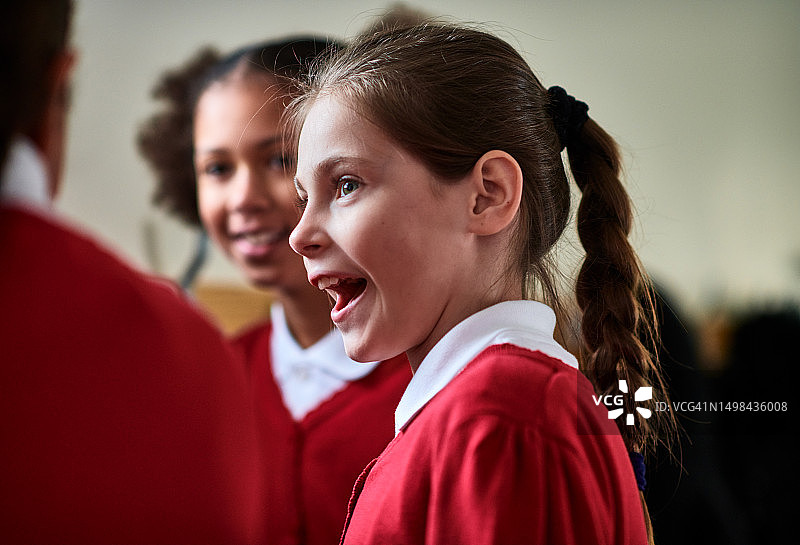 惊讶的女孩张着嘴巴，听着同学讲话图片素材