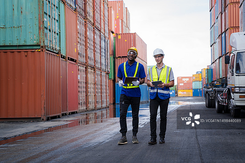 在货运堆场检查集装箱数据的管理员，来自货船的集装箱用于进出口图片素材