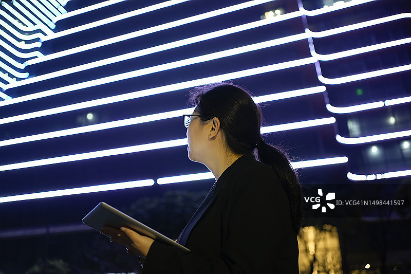 在建筑物下使用平板电脑的亚洲女商人图片素材