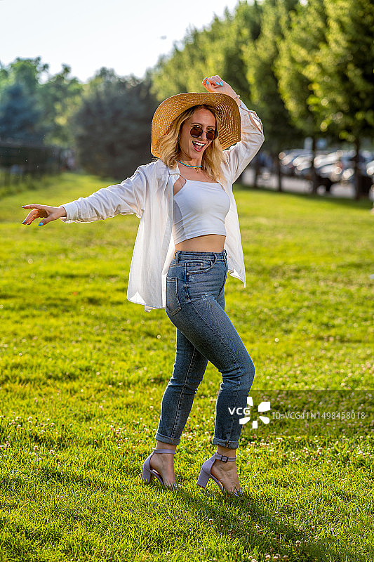 在户外戴着草帽和太阳镜的女人图片素材