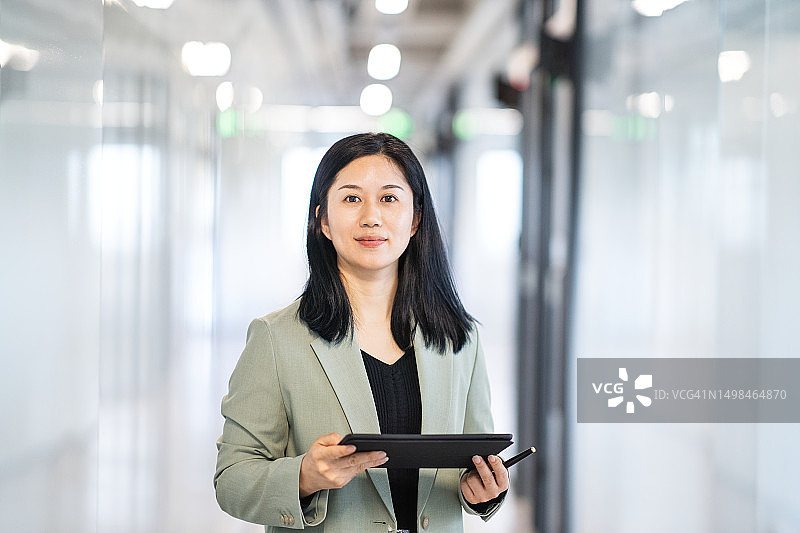 女性在走廊使用平板电脑工作图片素材
