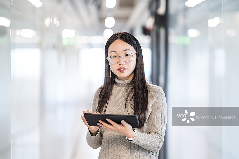 女性在走廊使用平板电脑工作图片素材