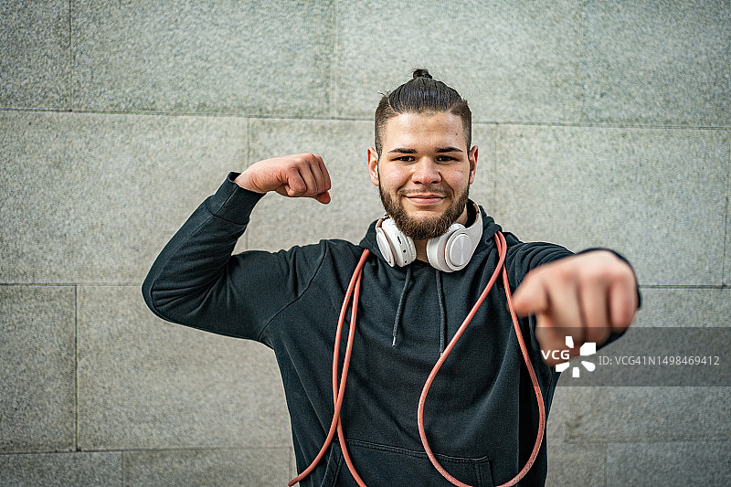 年轻的运动员肖像：背景为带文本空间的混凝土墙图片素材