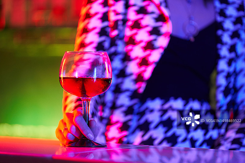 特写：在迪斯科舞厅拿着鸡尾酒杯的女人图片素材