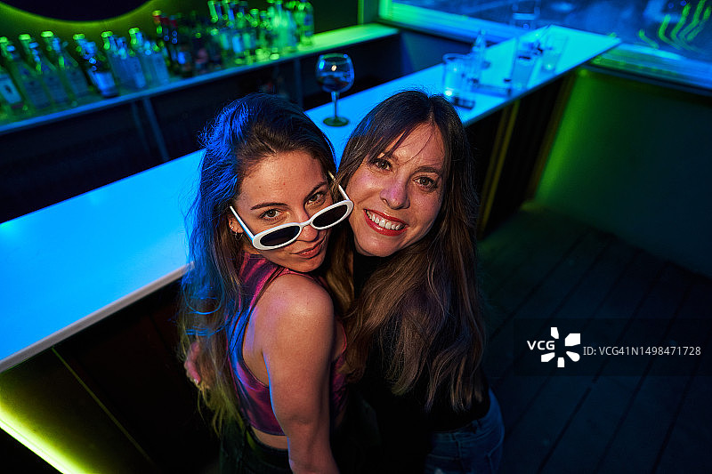 在俱乐部里，女人们看着镜头一起微笑图片素材