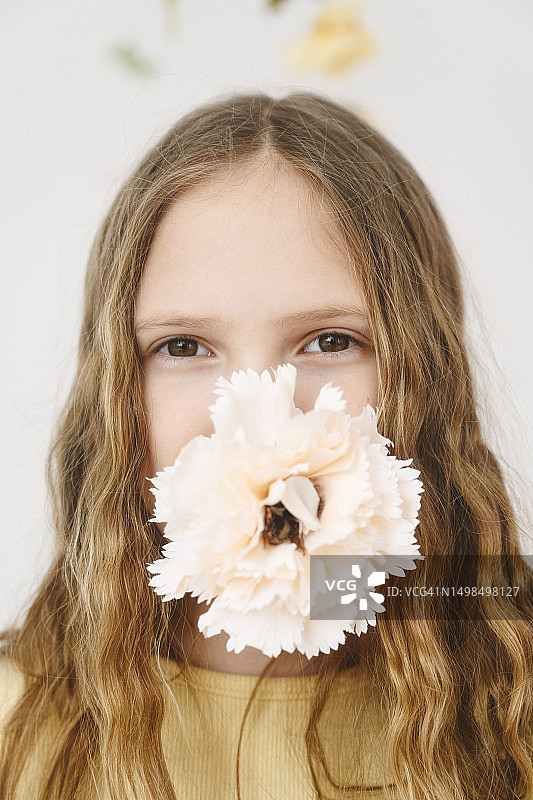嘴里含着鲜花的金发女孩图片素材