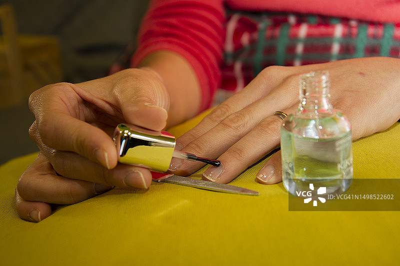在意大利，女子在桌子上涂指甲油的截面图片素材