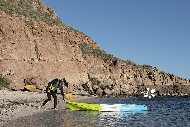 一位在加利福尼亚州卡门岛准备跳上皮划艇的女人图片素材