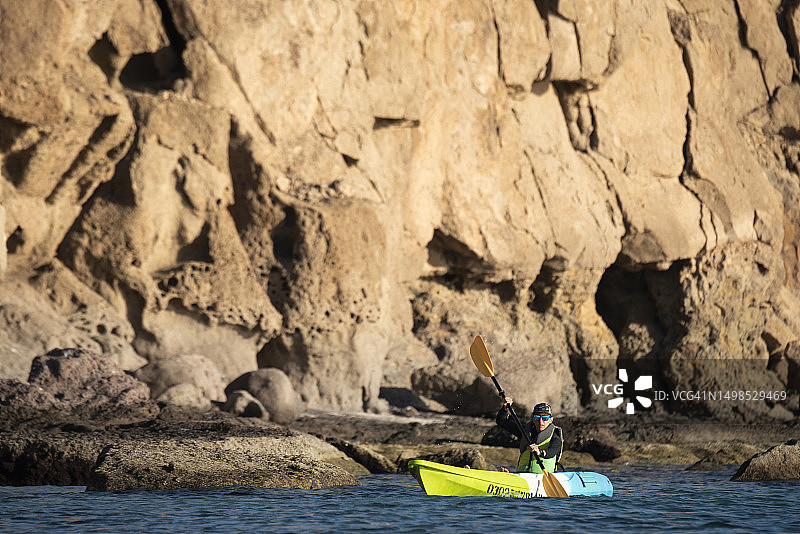 女子在墨西哥下加利福尼亚州洛雷托卡门岛海岸附近划皮划艇图片素材