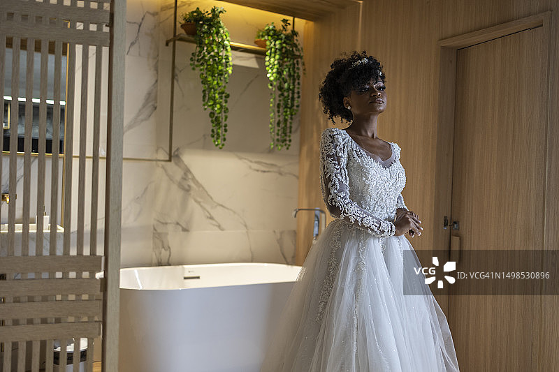 身穿新娘礼服的黑人女性在酒店房间里图片素材