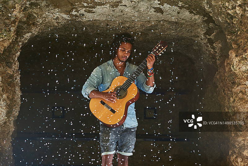 音乐家在洞穴里弹奏古典吉他图片素材