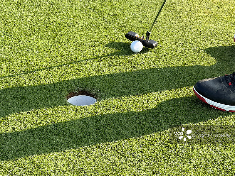 高尔夫球手将球打入洞中图片素材
