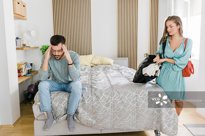 年轻夫妇关系不和，争吵后女人收拾行李离开图片素材