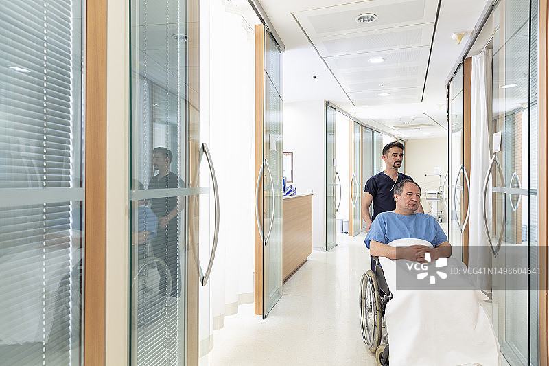护士在医院走廊用轮椅推送患者图片素材