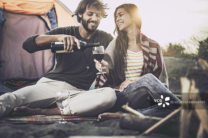 幸福情侣在海滩露营时享受美酒图片素材