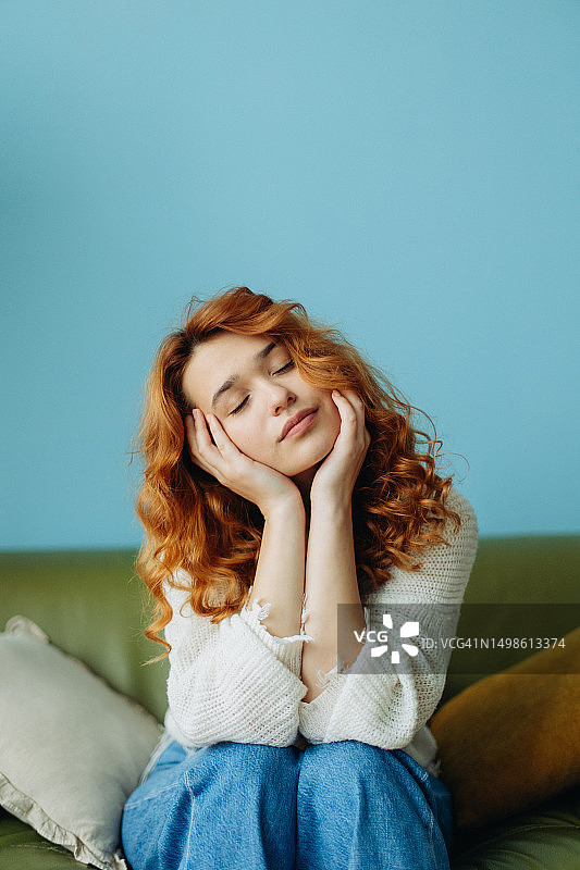 在舒适房间的桌旁用笔记本做笔记的美丽红发女人肖像图片素材