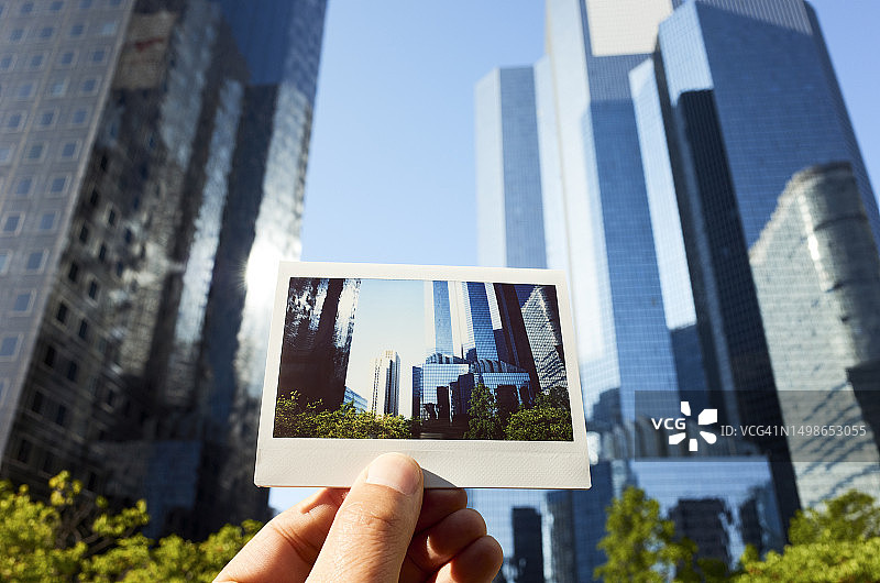 男人在场景前拿着拉德芳斯摩天大楼的即时胶片照片图片素材