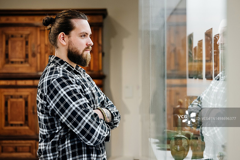 男人在博物馆展览前交叉双臂观看图片素材