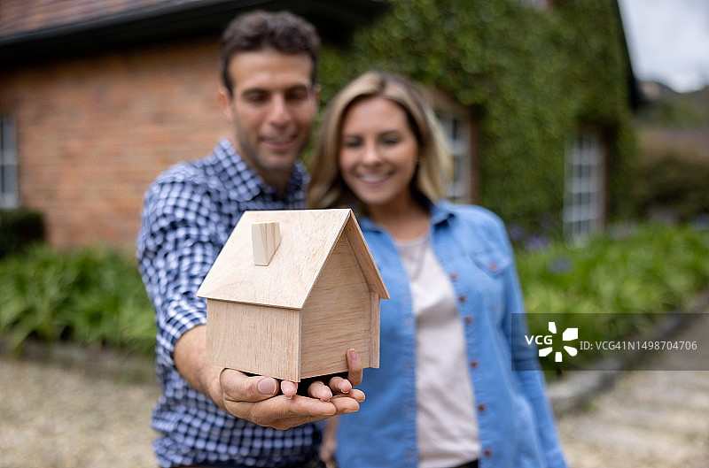 幸福的夫妇拿着一个房子模型 - 房地产概念图片素材