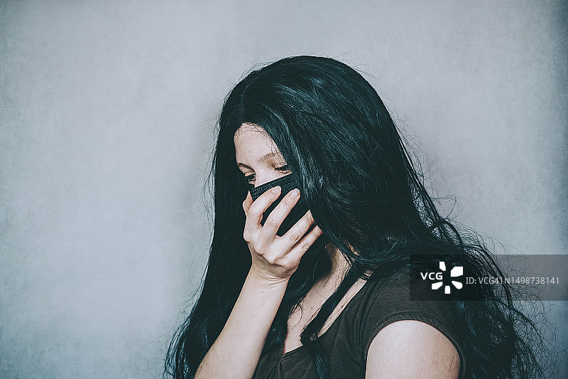 戴着太阳镜靠在墙上的年轻女人，西班牙布尔戈斯图片素材