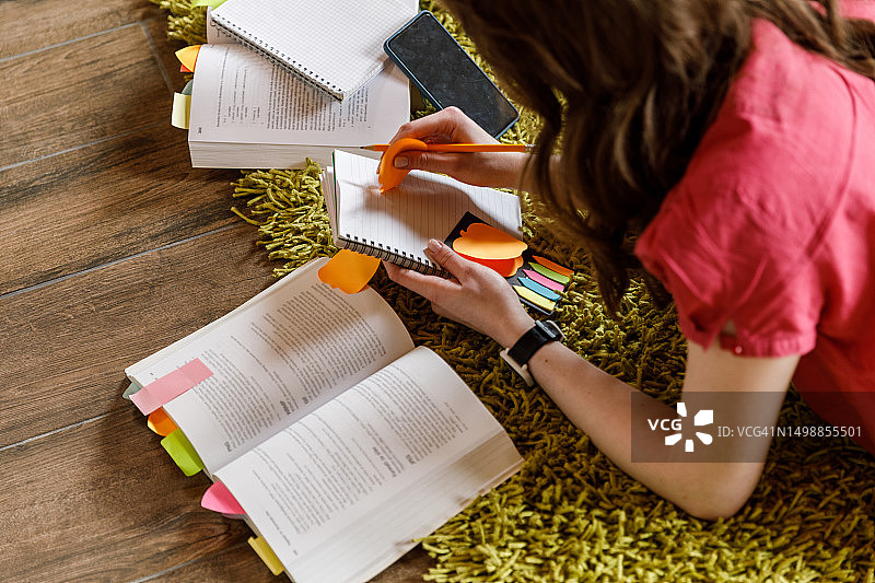年轻女子在备考时用便利贴标记重要页面图片素材