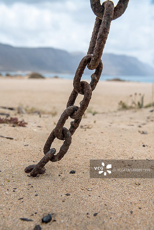 缠绕在沙子里的古董链条图片素材