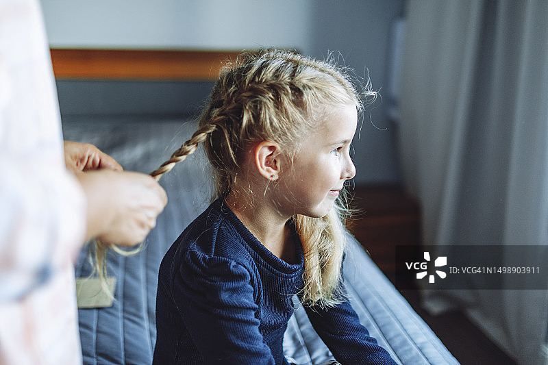 母亲为女儿编辫子上学图片素材