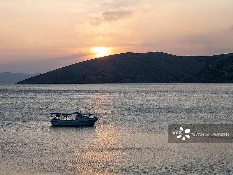 克罗地亚克尔克岛斯塔拉巴斯卡喀斯特山脉日落海湾的船图片素材