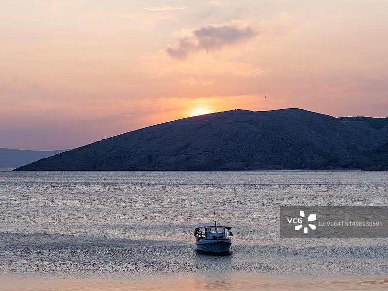 克罗地亚克尔克岛斯塔拉巴斯卡喀斯特山脉日落海湾的船图片素材