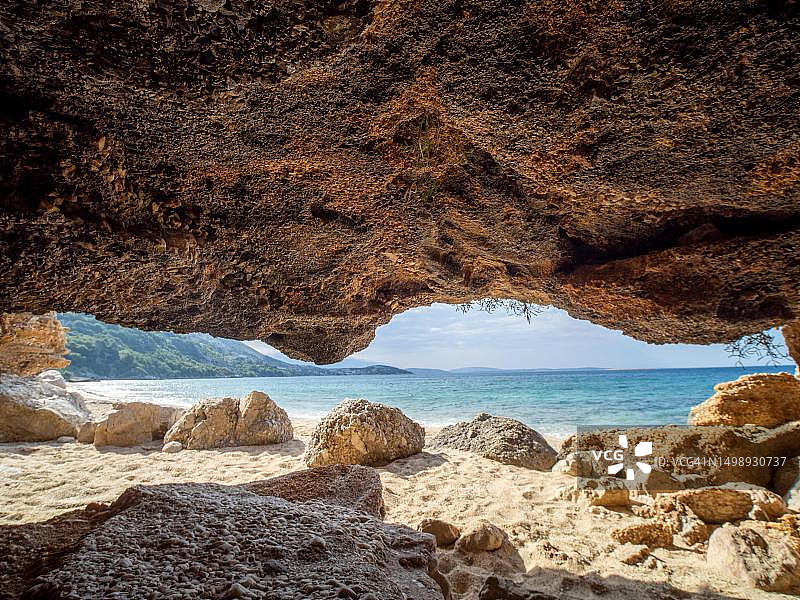 喀斯特洞穴，位于克罗地亚克尔克岛斯塔拉巴斯卡露营地附近的沙滩上图片素材