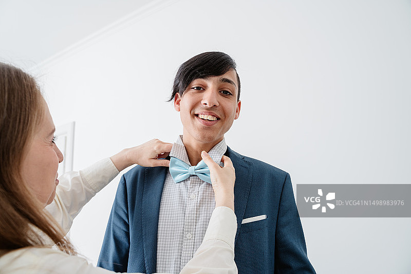 母亲为儿子准备毕业舞会图片素材