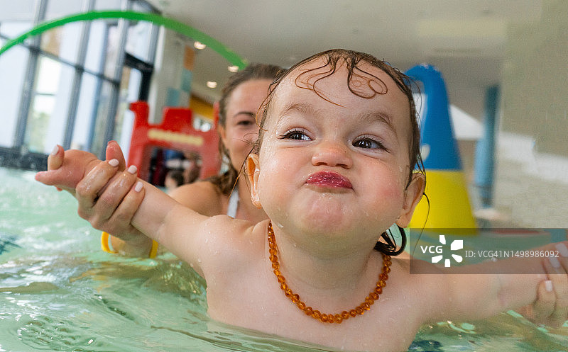 可爱的女孩在泳池里玩耍图片素材