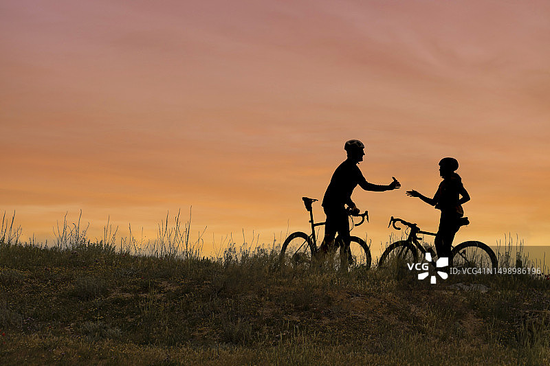 日落时分，几位骑自行车的人分享手机内容图片素材