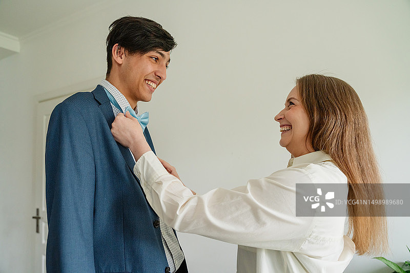 母亲为儿子准备毕业舞会图片素材