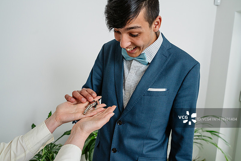 母亲为儿子准备毕业典礼并给他公寓钥匙图片素材