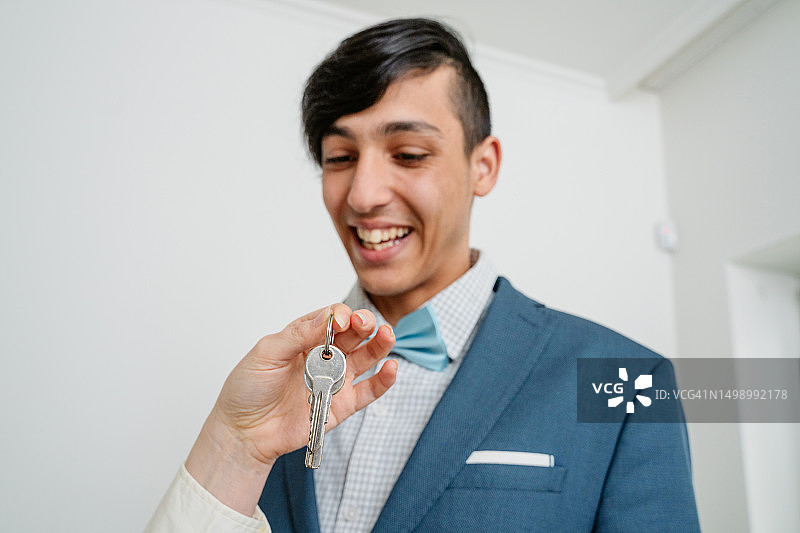 母亲为儿子准备毕业典礼并给他公寓钥匙图片素材