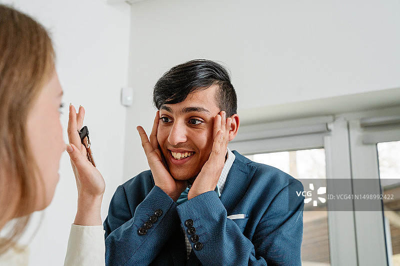 母亲为儿子准备毕业典礼并给他公寓钥匙图片素材