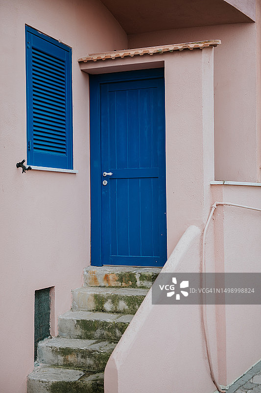 意大利粉红色墙壁上的古朴蓝色前门图片素材