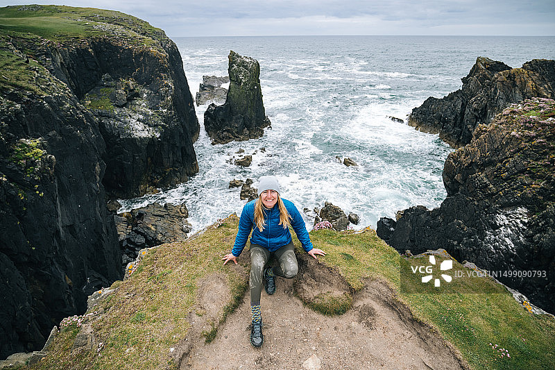 坐在海边悬崖上的女人肖像图片素材