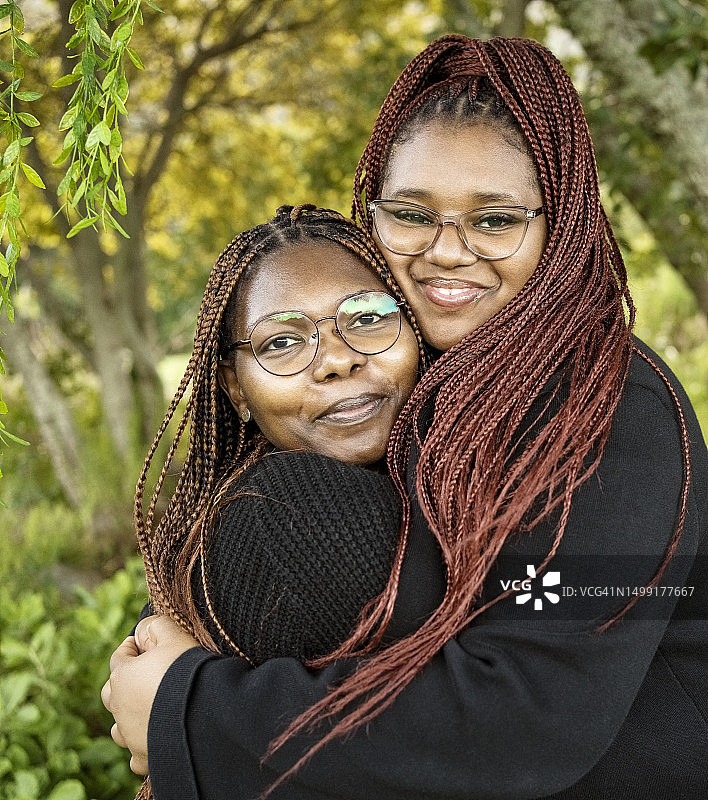 两个非洲裔姐妹在公园里拥抱微笑图片素材
