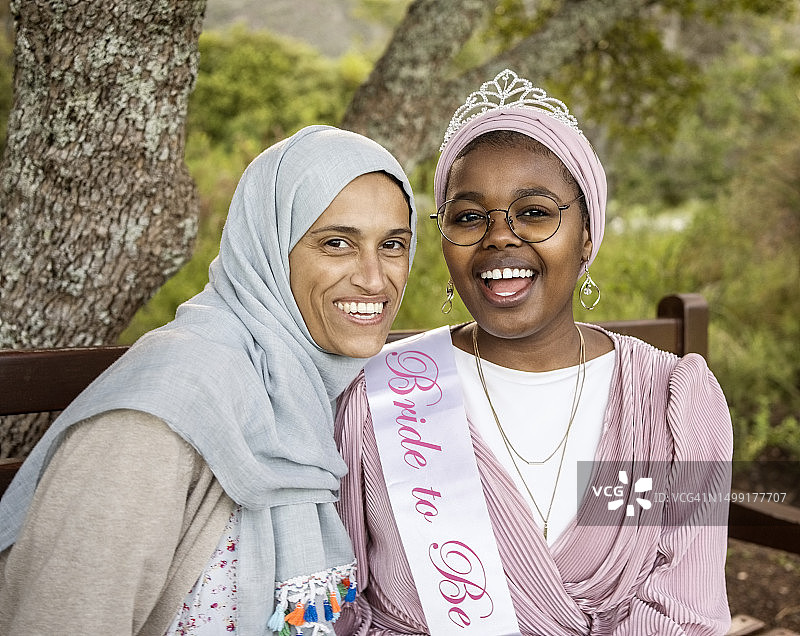 快乐的年轻新娘和伴娘在婚前派对上微笑图片素材