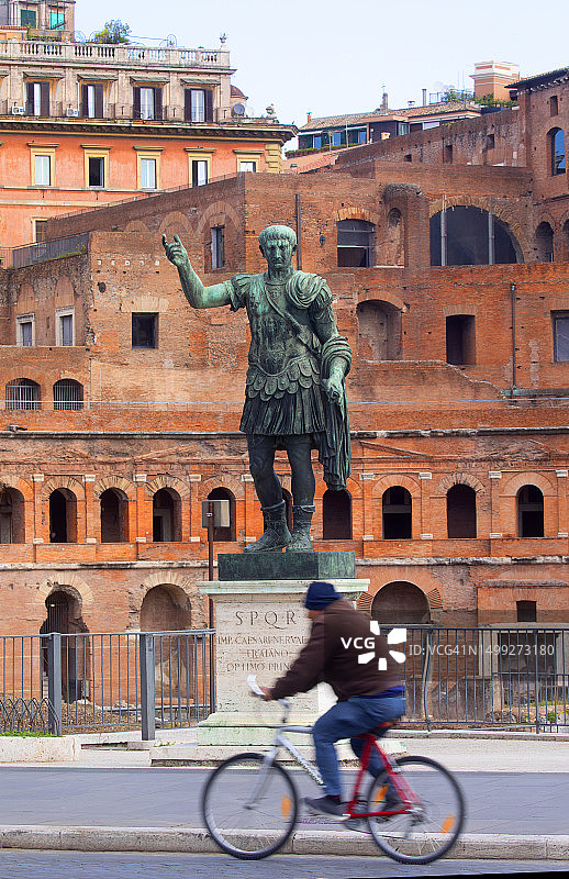 骑自行车经过雕像的骑行者图片素材