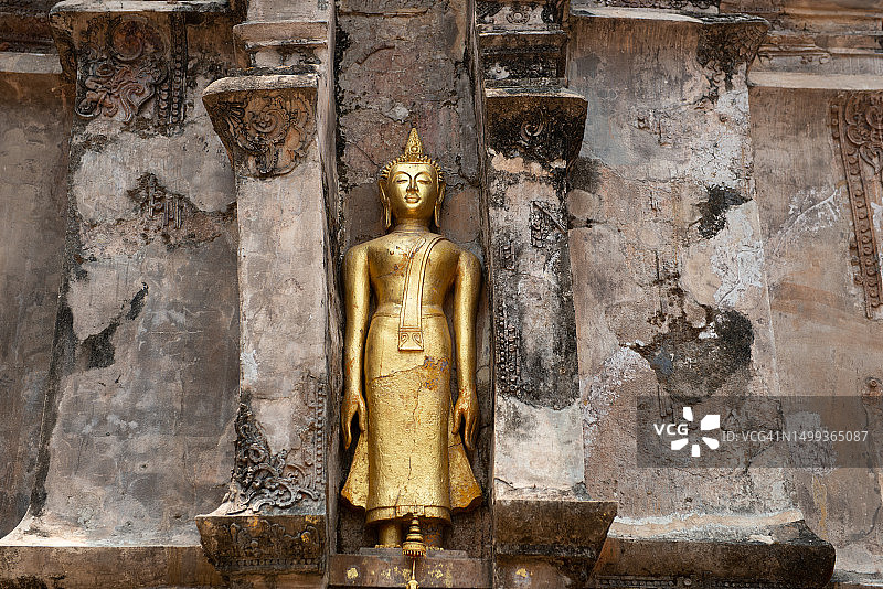 泰国清莱清盛Wat Phrathat Chom Kitti寺宝塔旁的金色佛像图片素材