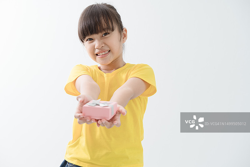 快乐的小女孩递上礼品盒，白色背景图片素材